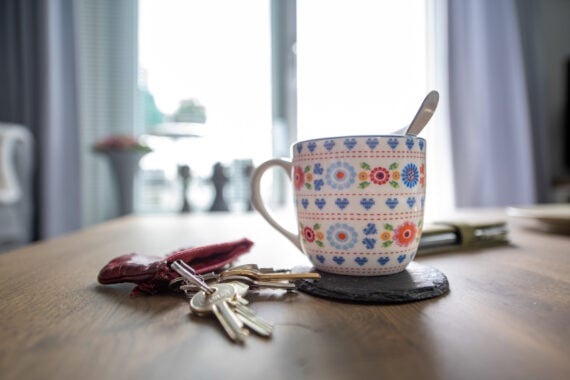 kop koffie op eettafel met sleutels ernaast
