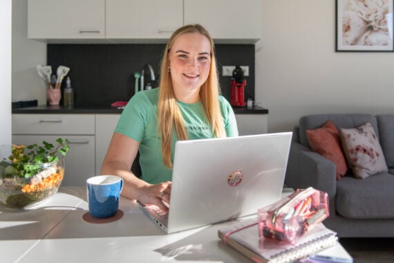 jonge vrouw in woonkamer met laptop