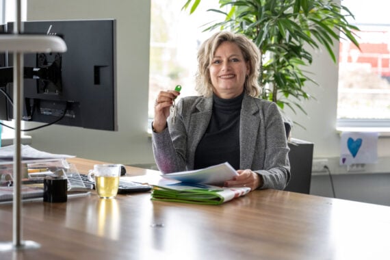 medwewerker achter bureau met sleutelbos