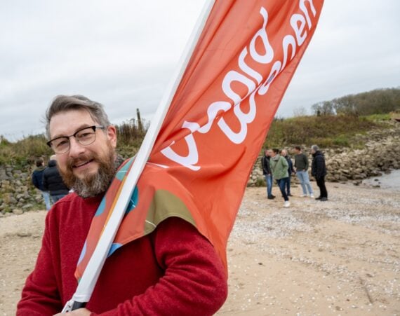 medewerker met Waardwonen vlag
